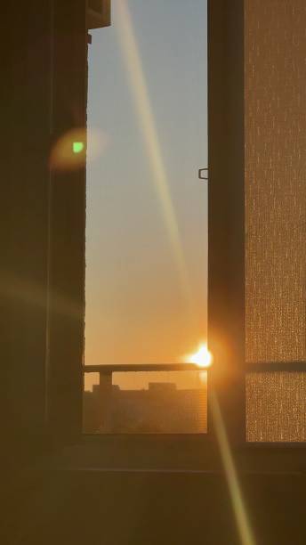 istock Golden sunrise behind a curtained window. 2150189652