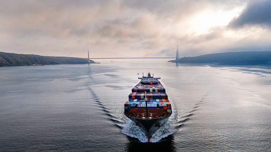 Aerial view of cargo container ship in transit in Istanbul Bosphorus. Aerial view of freight ship with cargo containers. Container ship is crossing the Bosporus in Istanbul, Turkey.