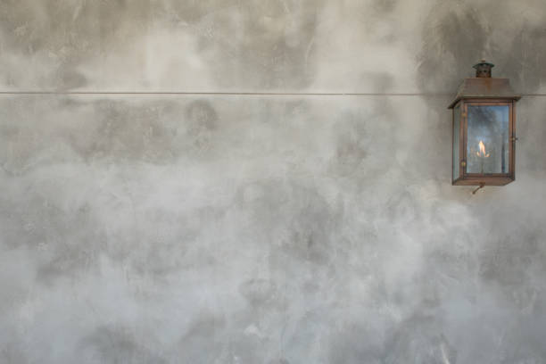 istock Gas lit lantern on bright gray stucco concrete wall background 2150192922