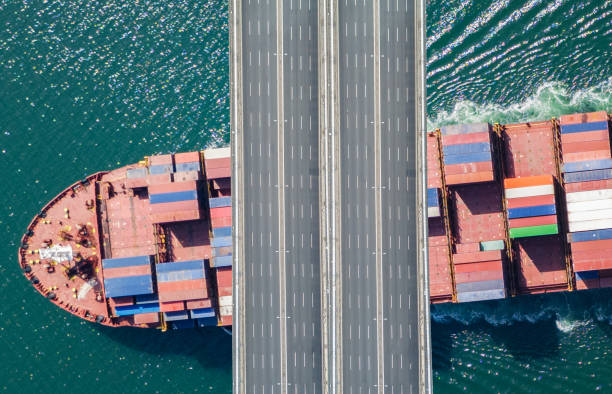 istock Aerial view of a cargo ship passing under bridge. 2150193882