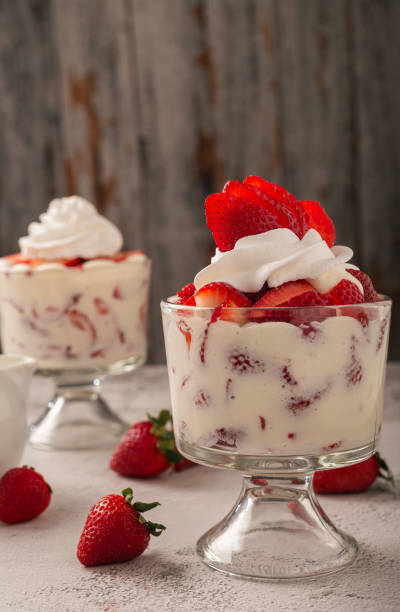 istock Strawberries with cream in a glass cup on cement table. Copy space. 2150196172