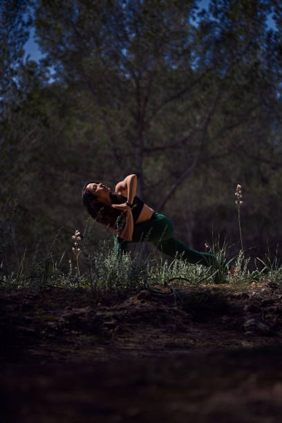 istock Woman doing Parivritta Utkatasana posture in forest 2150196820