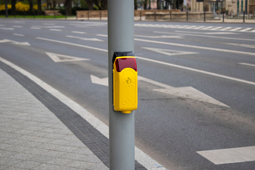 Crosswalk. Yellow button on a traffic light for pedestrians.