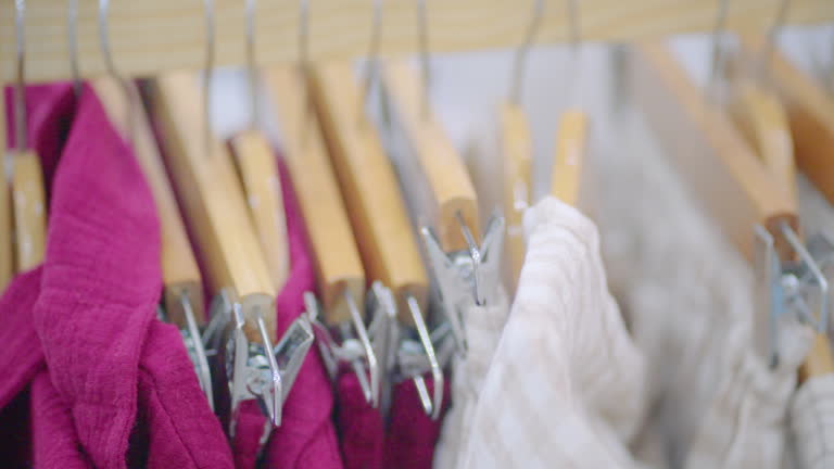 Natural colorful clothes hang on the rack collection in the store.
