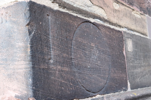 Measurement marked on stone to measure cheeses and breads in the Freiburg Cathedral Market, Germany. It is sculpted on the façade of the cathedral.