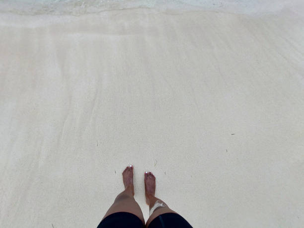 Top View Of Woman Standing On The Shore At A White Sand Beach