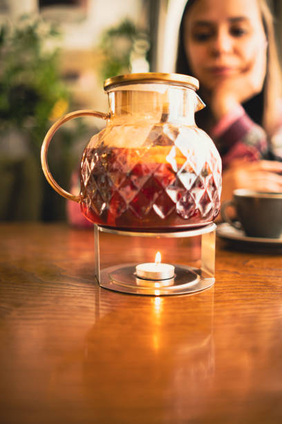 istock Jug of tea on rack with burning candle. 2150211491