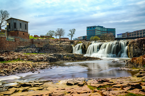 Sioux Falls City Spring Landscape at the Falls Park in Sioux Falls, South Dakota, USA, silky water falling over quartzite and pipestone rock formations in the Big Sioux River