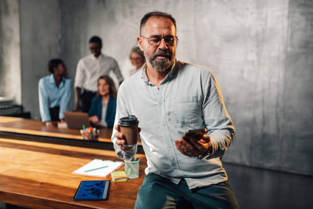 istock Mature executive using cellphone at boardroom during the meeting. 2150214734