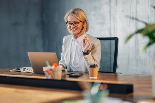 istock Mature businesswoman working on a laptop at modern workspace. 2150214744