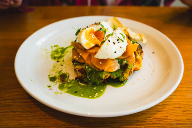 istock Potato waffle with salmon, poached egg in spinach sauce on white plate. 2150216467