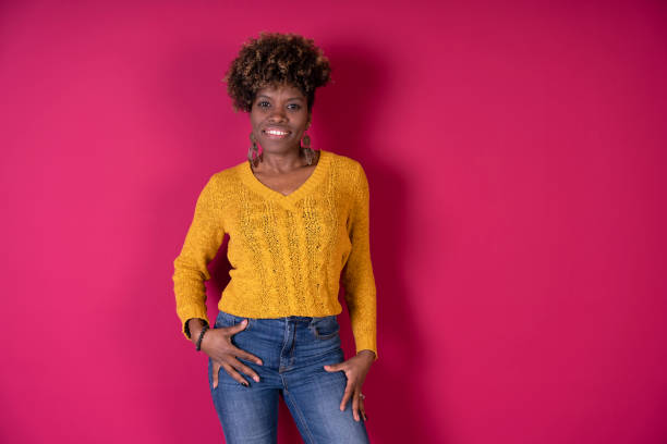 A woman stands in front of a vibrant pink wall with ample copy space for text or design elements.