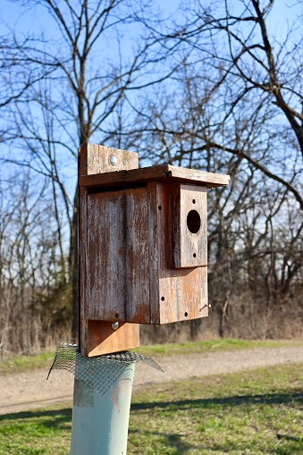 A close view of the old wood birdhouse in the country field.