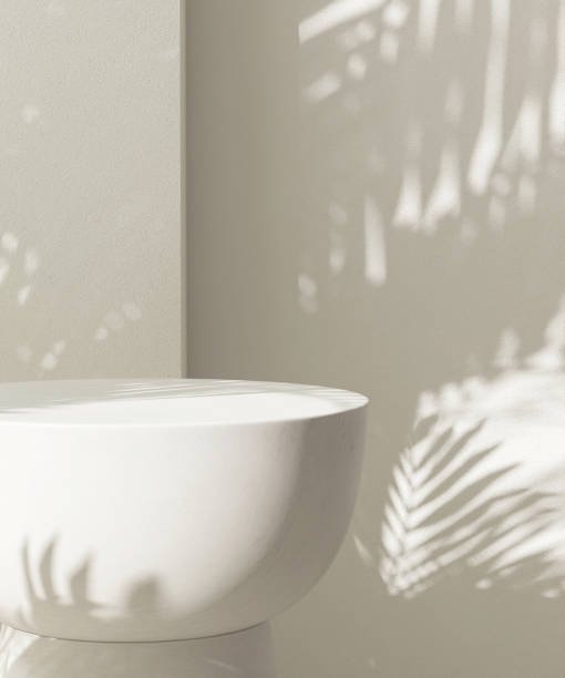 istock Cream white round podium table in sunlight, palm tree leaf shadow on wall 2150225952