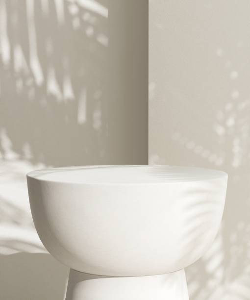 istock Cream white round podium table in sunlight, palm tree leaf shadow on wall 2150225954