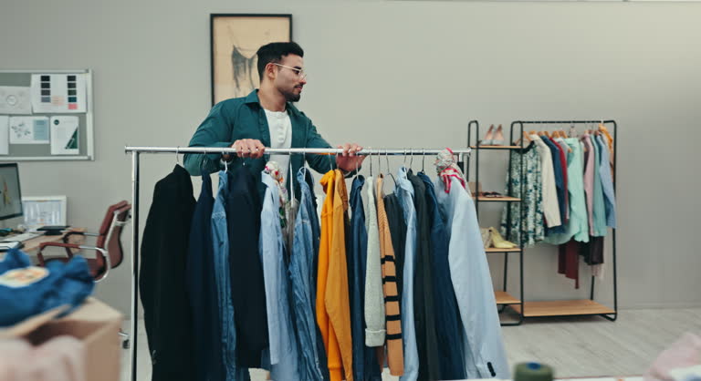 Small business, startup and man with fashion rail in boutique for clothes, display or stock setup. Supply chain, startup and male retail store owner at mall with outfit selection, wardrobe or storage