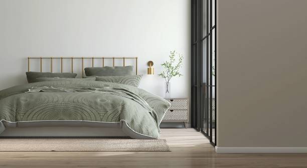 istock Blank beige wall space in modern, luxury bedroom with brass headboard bed, sage green bedding, rattan bedside table, wall lamp in sunlight from glass wall 2150226286