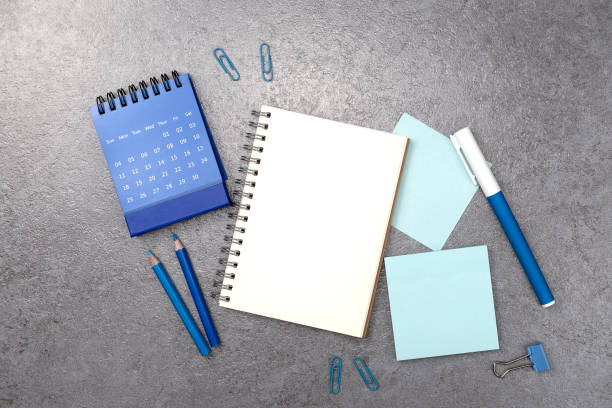 istock Notebook and blue stationery on stone texture background. Work desk space 2150226903