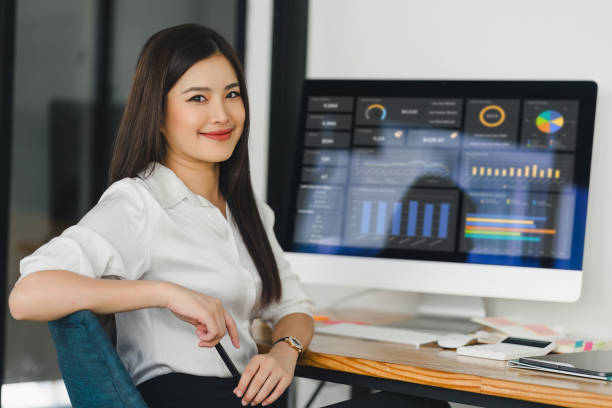 istock Asian businesswoman or accountant are analyzing data charts, graphs, and a dashboard on desktop screen in order to prepare a statistical report and discuss financial data in an office. 2150227195