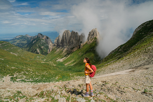 Woman  with backpack hiking in Swiss Alps at high altitude near the rescue hut
