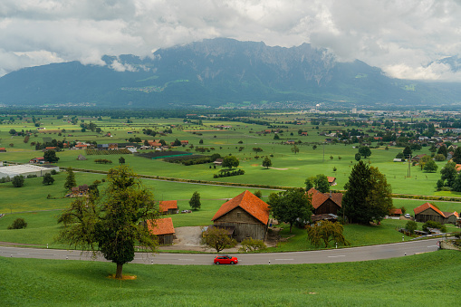 Car passing  an idyllic village Swiss Alps in summer