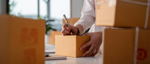 istock Woman entrepreneur prepare parcel box and check online order on laptop computer for commercial checking delivery. online marketing, packing box, SME seller. startup business concept 2150232951