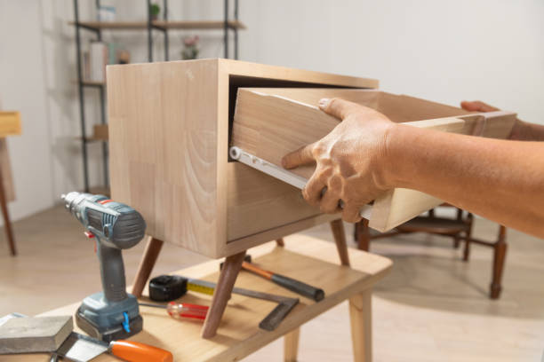 istock Handyman fixing over tight drawer slides rail of bedside table. 2150237505