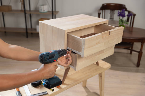 istock Handyman fixing over tight drawer slides rail of bedside table. 2150237545