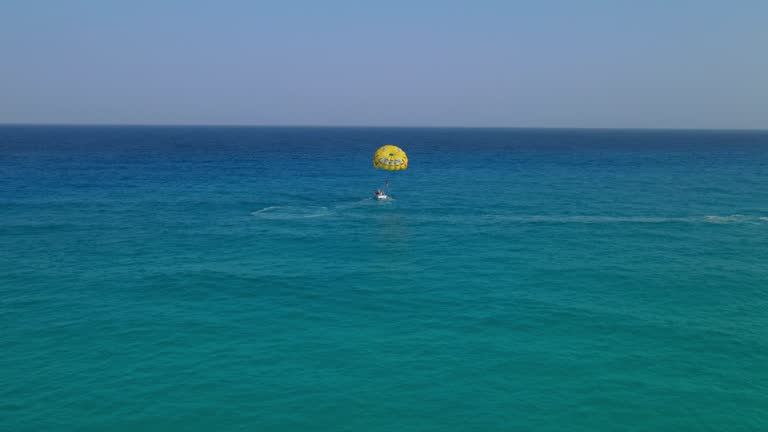 VIew of a boat in the middle of the sea holding the paraglider