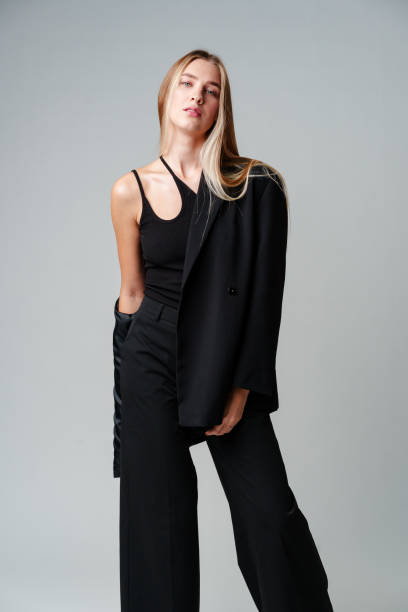 istock Young Woman Model in Black Top and Pants Posing on gray background 2150249655