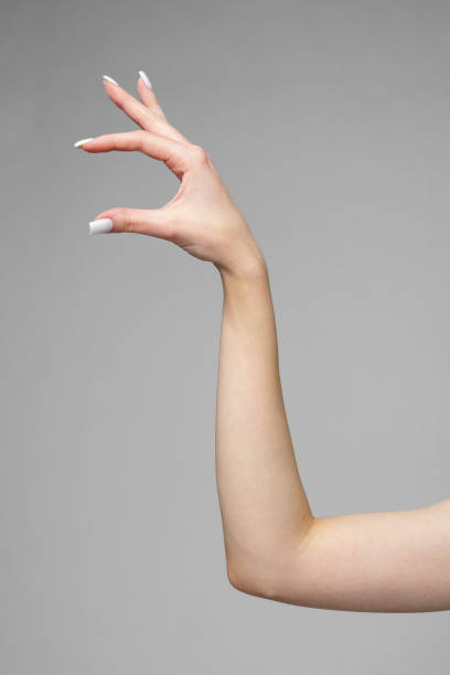 Female hand gesturing sign against gray background close up
