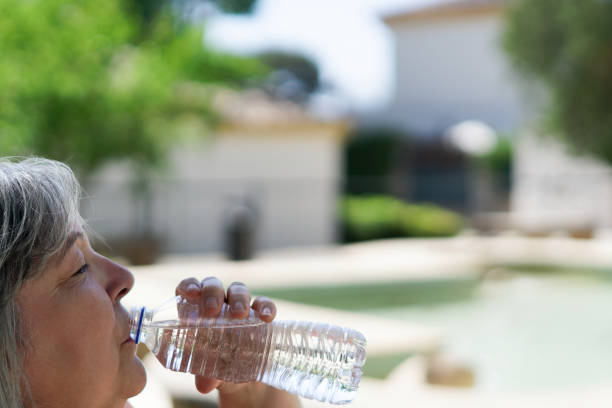 istock woman seen in profile drinking water from a plastic bottle 2150250541