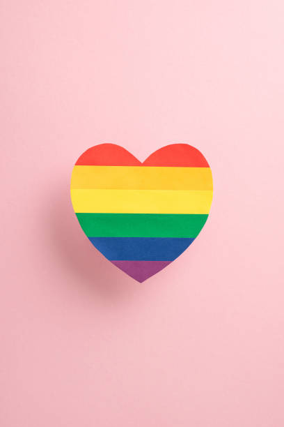 istock A vibrant vertical rainbow-colored heart symbol on a soft pink background, representing love and unity during Pride Month 2150252298
