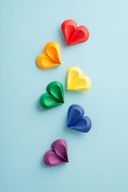 istock Vivid vertical multi-colored paper hearts arranged in a floating pattern on a gentle blue backdrop, symbolizing diversity and love during Pride Month 2150252314