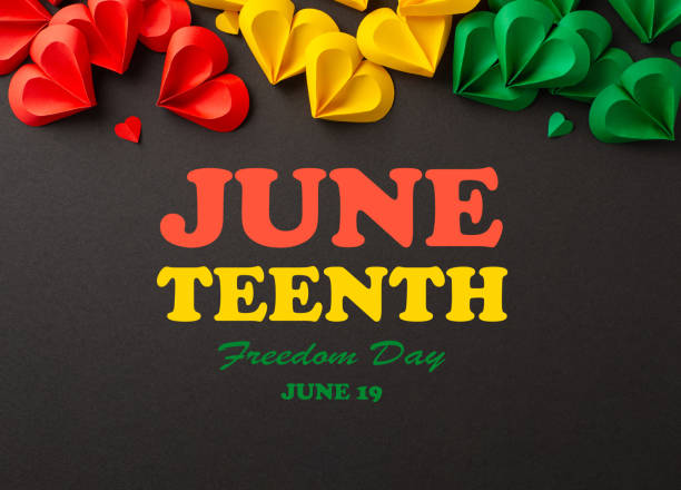 istock Emancipation celebration: hearts in red, green, yellow on black, symbolizing Juneteenth's end of slavery. Top view photo with text inscription on it 2150252321