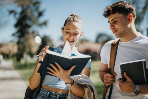 istock Young students with notebooks studying together in a sunny urban park 2150254527