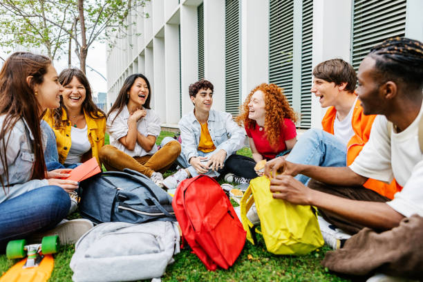 istock Diverse group of university students sitting on grass at campus college 2150255296