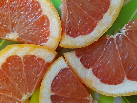 Sliced grapefruit on green plate.