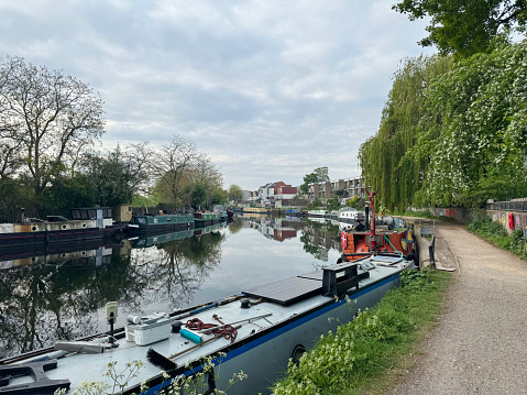 House boats and narrow boats on River Lee Navigation at Tottenham Hale, in north London. April 2024