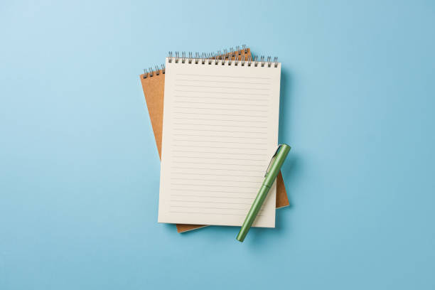 istock Top view of notebook and fountain pen on blue background 2150258130