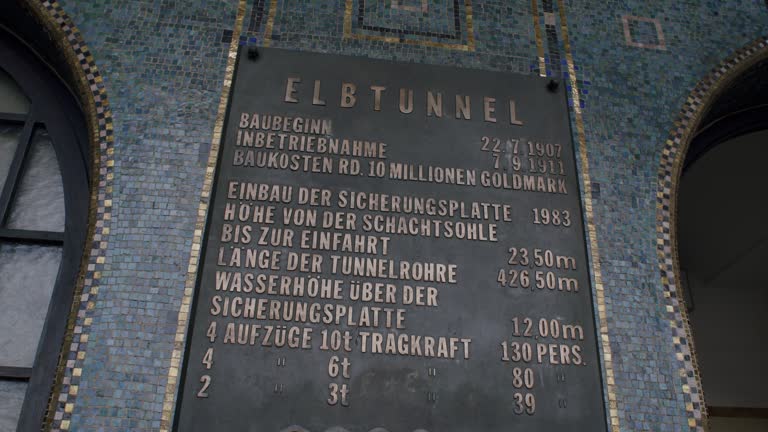 Old Elbtunnel entrance sign in Hamburg, historic tunnel information displayed on a tiled wall