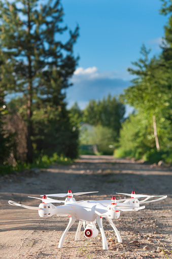 Drone on the sandy road, ready for takeoff.