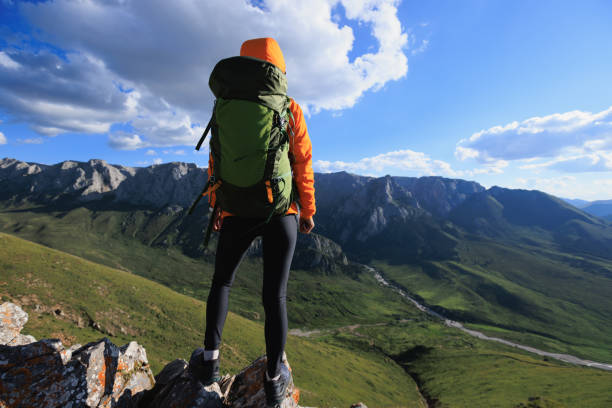 istock Woman backpacker hiking on sunset alpine mountain top 2150261396
