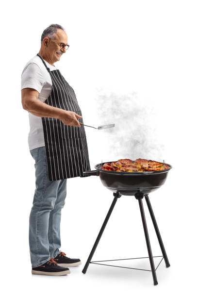 istock Mature man grilling meat on a barbecue 2150263439