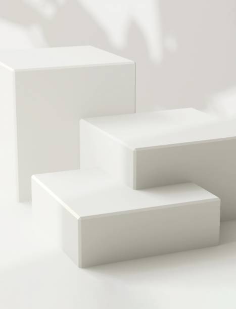 istock Three white glossy modern cuboid podium, geometric pedestal in dappled sunlight, leaf shadow 2150266235