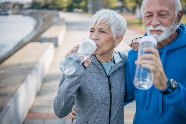 istock Senior couple rests by the river while drinking water 2150266669