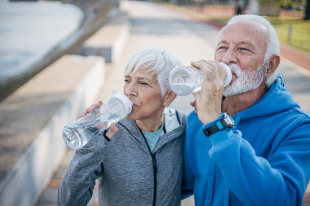 istock Senior couple rests by the river while drinking water 2150266671