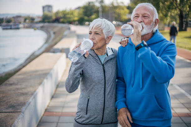 istock Senior couple rests by the river while drinking water 2150266757