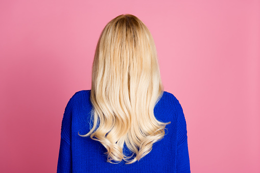 Rear behind photo of lady strong healthy wavy hair wear blue sweater isolated on pink color background.