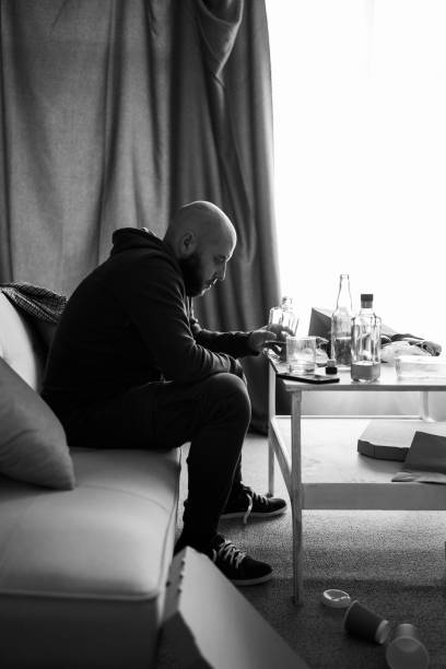 istock drunk man at home on couch holding whiskey glass, having alcoholism problem. alcohol abuse, depression and addiction 2150268031